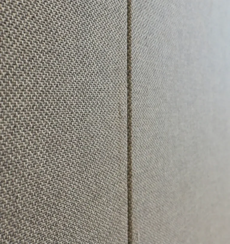 Detaljbild av en textilklädd akustikpanel som används för ljudisolering kontor.